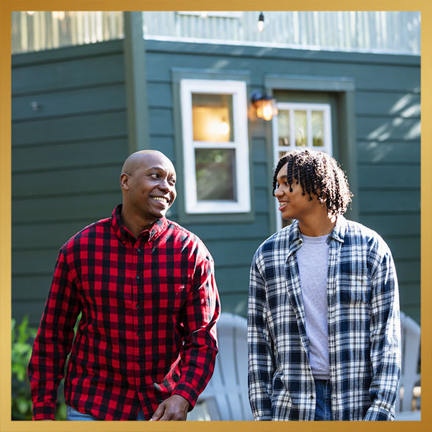 Father and teenage son conversing in back yard