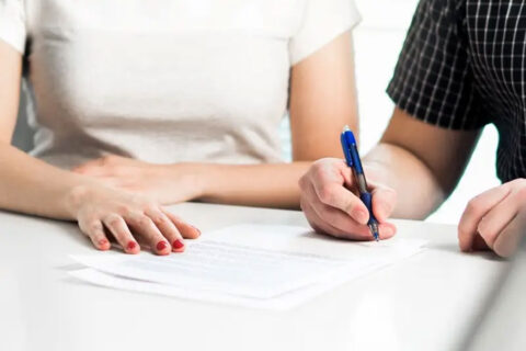 A couple signs divorce papers at a family lawyer’s office in Tucson, AZ
